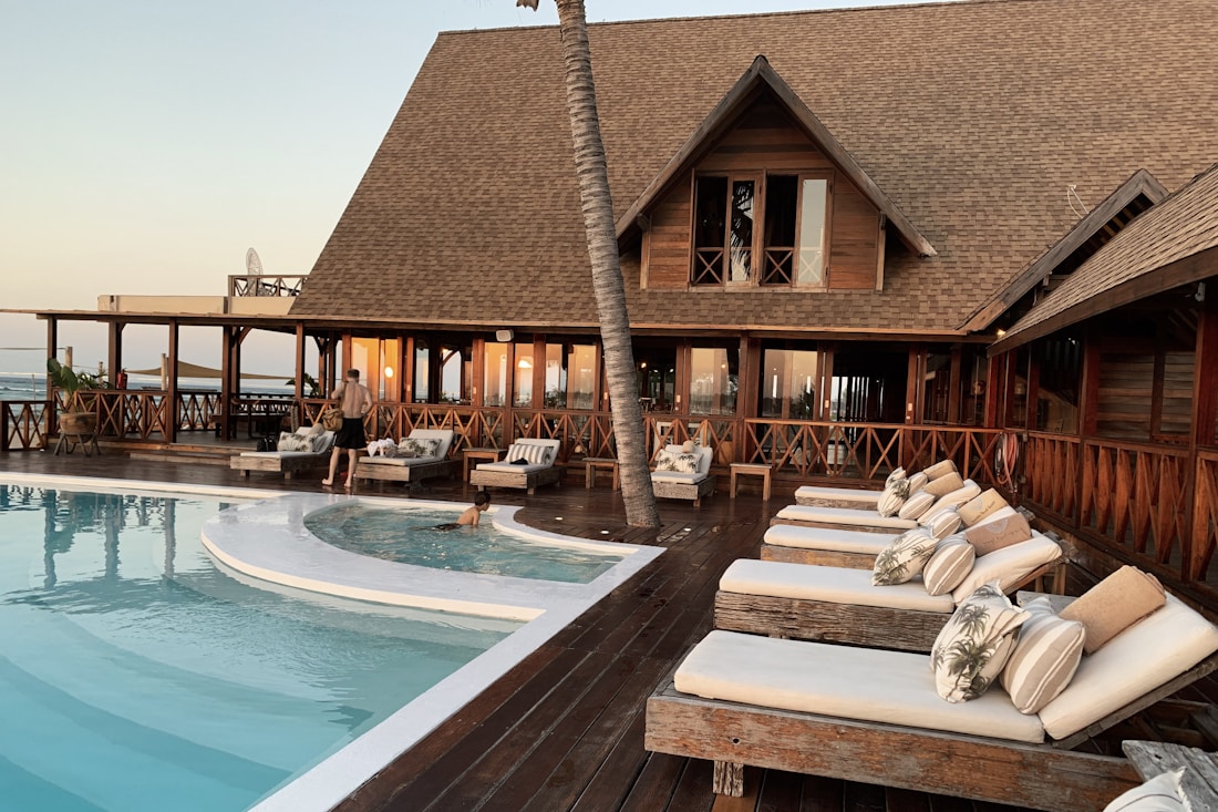 Hotel courtyard with a pool, palm trees, and guest terraces